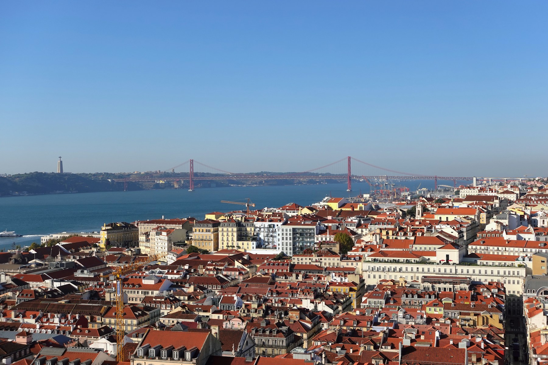 Lisbon’s terracotta rooftops overlooking the Tagus River, the 25 de Abril Bridge, and Cristo Rei